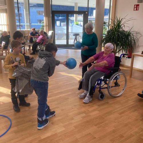 Kinder werfen Ball alten Menschen zu